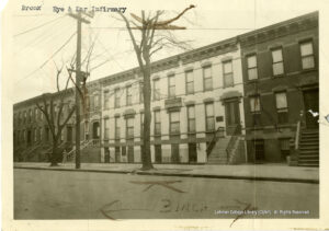 Image of several row houses, one of which has a sign saying Bronx Eye & Ear Infirmary