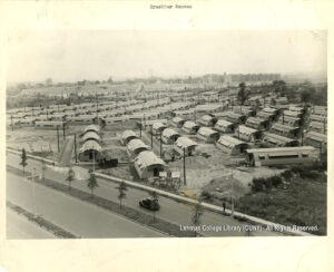Image of dozens of Quonset huts at Bruckner Boulevard and Boynton Avenue, facing east. In the distance is the Bronx-Whitestone Bridge and Clason Point Gardens housing project.