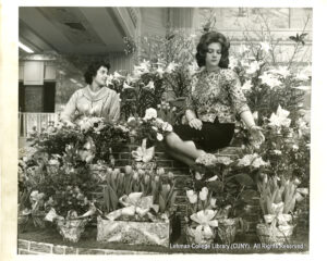 Image of two women surrounded by flowers.