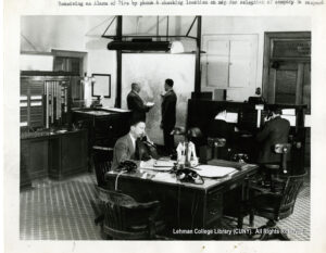 Image of two men in suits on phones at a desk, and two men looking at a map.