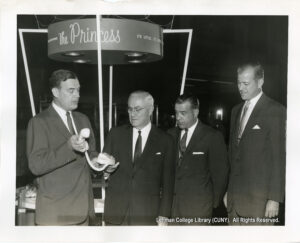 Image of a man demonstrating a telphone to several others.