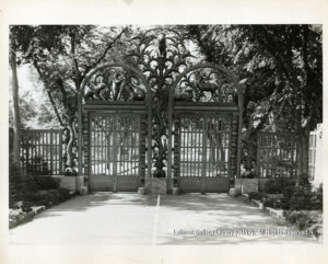 Image of ornate metal gates and trees.