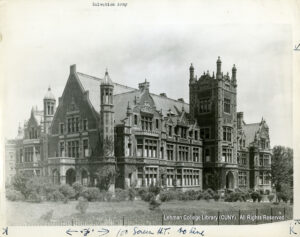 Image of an ornate, castle-like building surrounded by bushes and trees.