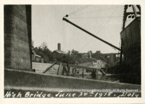 Image of the barge's wreckage. A sign saying "No. 7" is visible next to a boat and a bridge pylon.