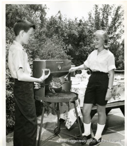 Image of a boy and a girl who appear to be barbecuing meats.