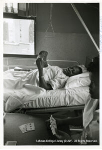 Image of a patient playing cards with a staff member. A window and a handle are present.