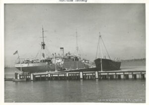 Image of two ships moored to a pier.