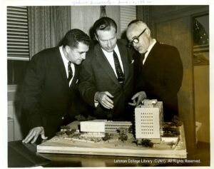 Image of three men in suits looking at an architectural model.