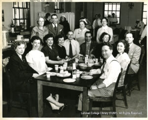 Image of men and women seated around a table eating from plates