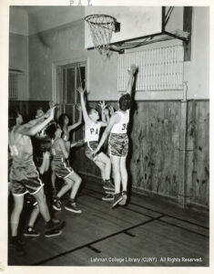 Several young men jumping with a ball in front of a basketball net
