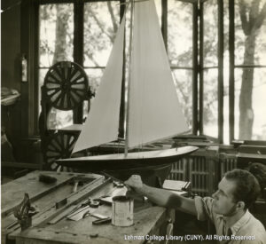 Image of a white male student looking up at a model sailing yacht