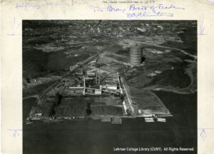 Image of a gas power plant which borders the water. There is no development in the immediate vicinity but buildings look on in the distance.