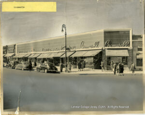 Image of a street scene at Fordham Rd. & Creston Ave. showing newly opened stores, including Cromwell's, following a four alarm fire that destroyed the stores the previous year.