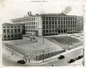 Image of a high school with athletic courts, peopel walking, and 1930s cars.
